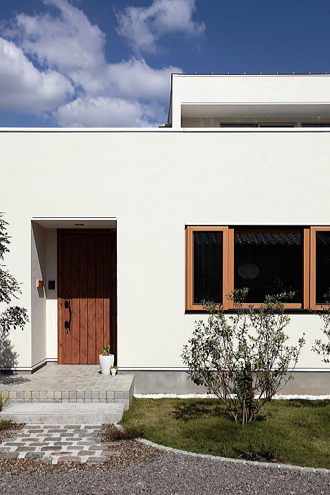 真っ白の外壁と木製建具が特徴的